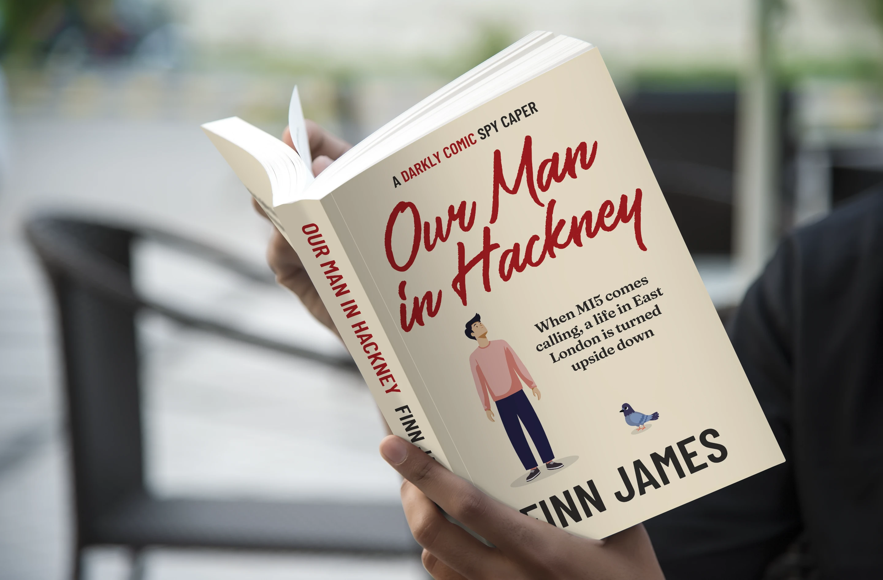 Somebody reading a copy of Our Man in Hackney by Finn James